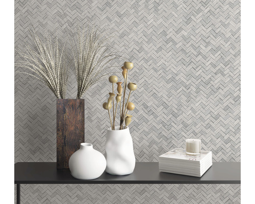 Wandgestaltung mit Fischgrätmuster und Dekorationsgegenständen auf einem schwarzen Tisch