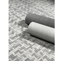 Zwei gerollte Teppiche auf einem gewebten Untergrund