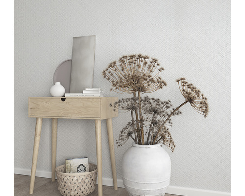 Dekorative Szene mit Holztisch, weisser Vase mit Blumen und geometrischer Tapete