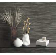 Dekorative Szene mit Vasen und Zierpflanzen vor einer gemusterten Wand.