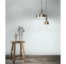 Espace de vie avec papier peint à motif ondulé, suspensions, tabouret et décoration