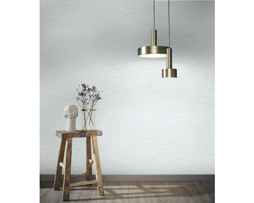 Espace de vie avec papier peint à motif ondulé, suspensions, tabouret et décoration