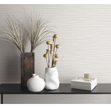 Dekoratives Stillleben mit Vasen, Ziergräsern, Buch und Kerze auf einem Regal