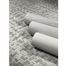 Trois rouleaux de papier peint textile sur un fond tressé