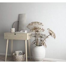 Dekorative Szene mit einem Beistelltisch aus Holz, einer Vase mit Trockenblumen und dekorativen Accessoires.