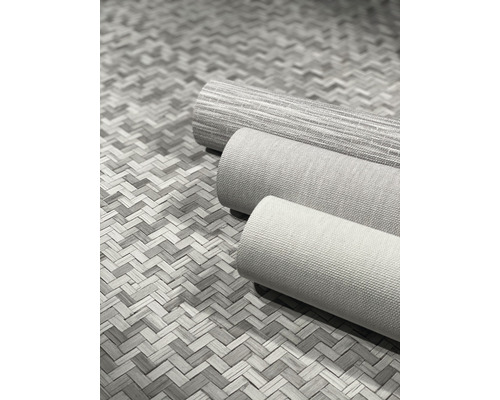 Drei Rollen Textiltapeten auf einem geflochtenen Untergrund