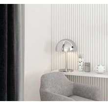 Dekoratives Wohnzimmer mit grauem Sessel, silberner Lampe und floralen Akzenten