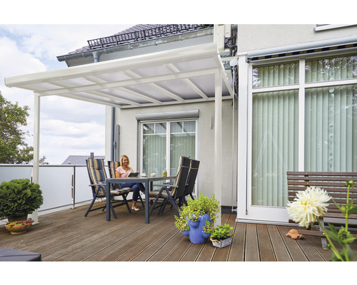 Überdachte Terrasse mit Sitzgruppe und lesender Frau