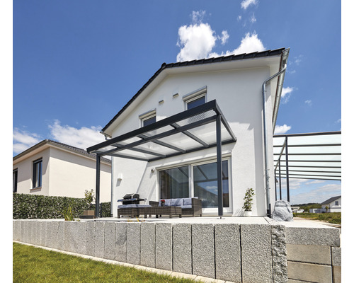 Terrasse avec toit de terrasse, barbecue et coin salon devant une maison