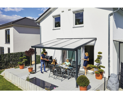 Une famille fait des grillades sous un toit de terrasse sur une terrasse.