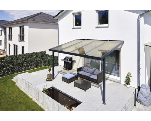 Terrasse avec toit de terrasse, barbecue, coin salon et bassin dans le jardin