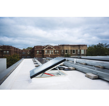 Aufnahme einer Dachterrasse mit Dachfenster und Solarpanelen.