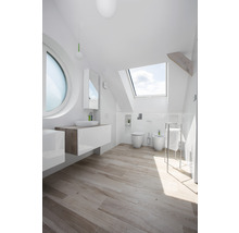 Helles Badezimmer mit Dachfenster, Waschbecken, Toilette und Bidet.