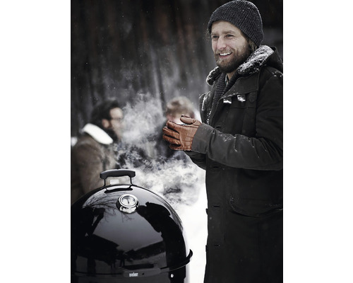 Szene mit einem Mann, der im Winter im Freien in der Nähe eines Grills steht