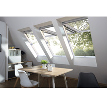 Innenansicht eines Dachgeschosses mit drei Dachfenstern über einem Esstisch.