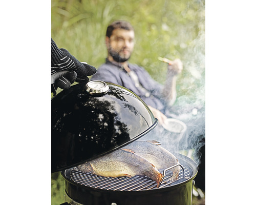 Fisch auf einem Holzkohlegrill mit Thermometer im Garten