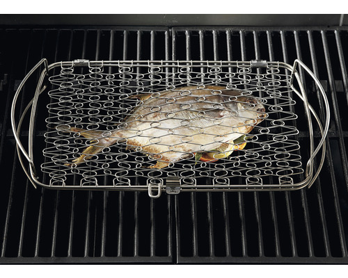 Un poisson dans une pince à griller sur une grille de barbecue.