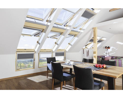 Pièce mansardée avec fenêtres de toit, table à manger et chaises