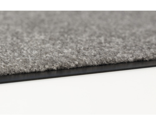 Detailaufnahme einer grauen Fußmatte mit Gummirand