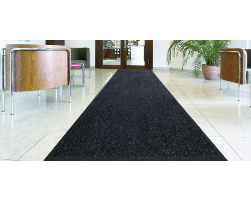 Long tapis de couloir foncé dans un hall avec carrelage.