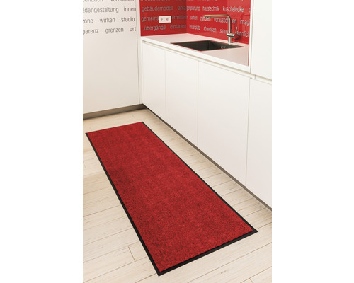 Tapis de cuisine rouge avec bordure noire devant un îlot de cuisine blanc