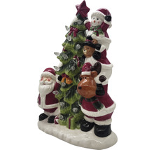 Décoration de Noël avec le Père Noël, un bonhomme de neige, un ours en peluche et un renne à côté d''un sapin de Noël