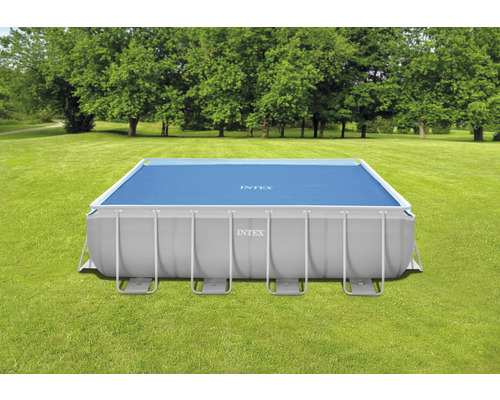 Rechteckiger Intex Pool mit blauer Abdeckung auf einer Wiese