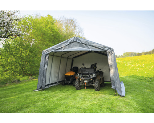 Garage grise pour outils de jardin avec une tondeuse à gazon et un quad dans le jardin