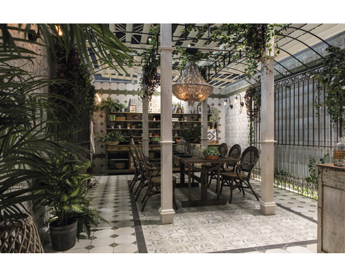 Esszimmer mit Esstisch, Stühlen, Regalen und Zierpflanzen unter einer Pergola.