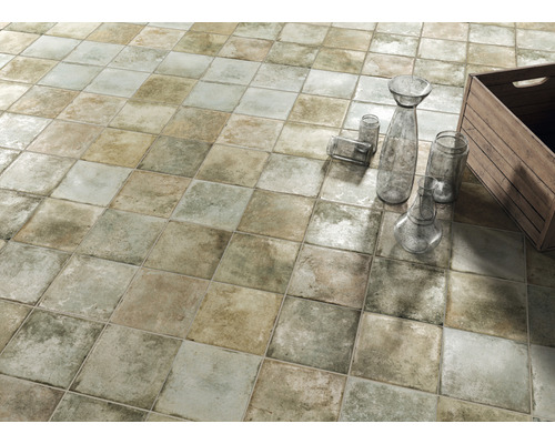 Quadratische Bodenfliesen verlegt im Schachbrettmuster mit Dekorationsgegenständen.