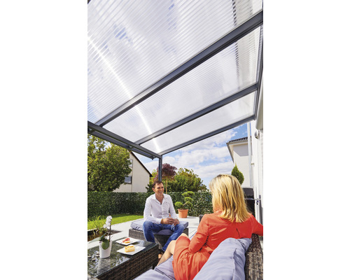 Terrassenüberdachung gutta Premium Polycarbonat bronze 510 x 306 cm anthrazit Terrassenüberdachung mit transparenten Platten und zwei Personen im Garten