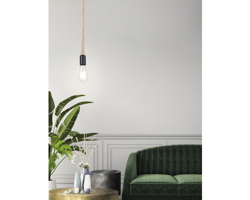 Dekoratives Wohnzimmer mit einer Seilpendelleuchte über einem Couchtisch, einem grünen Sofa und Zimmerpflanzen.