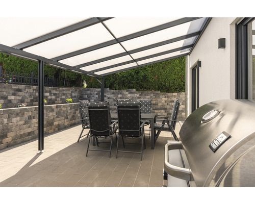 Terrasse avec barbecue, table de jardin et chaises sous un toit de terrasse