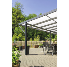 Terrassenüberdachung mit Gartenmöbeln auf einer gepflasterten Terrasse