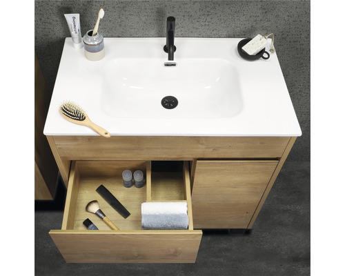 Waschtischunterschrank aus Holz mit offenem Schubfach und diversen Badutensilien auf dem Becken