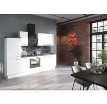 Cuisine moderne avec façades blanches, hotte aspirante et table à manger dans un espace de type loft avec un mur en briques.