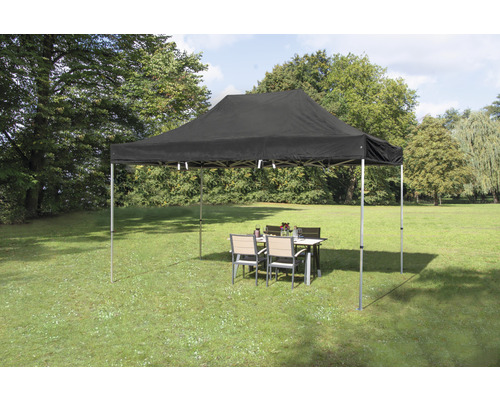 Tente pliante noire avec table et chaises dans le jardin