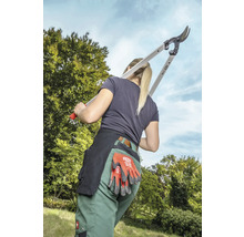 Femme avec sécateur à branche, gants de travail et ceinture à outils pour le jardinage