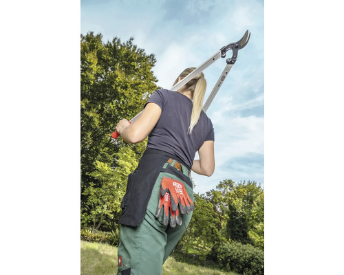 Femme avec sécateur à branche, gants de travail et ceinture à outils pour le jardinage