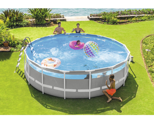 Piscine familiale avec structure en acier, échelle et accessoires de piscine dans le jardin.