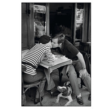 Schwarzweißfoto von einem Paar, das sich in einem Café küsst, mit einem Hund, der unter dem Tisch liegt.