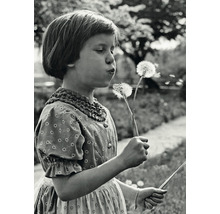 Fille soufflant sur des pissenlits dans le jardin