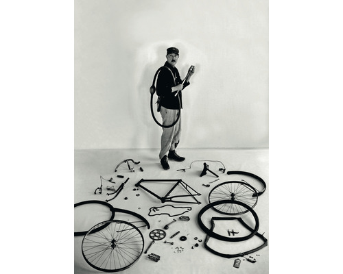Mann mit Fahrradpumpe und zerlegtem Fahrrad