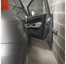 Voiture dans un garage avec porte ouverte et butoir mural pour protéger la porte.
