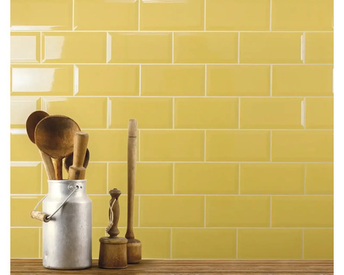 Carrelage mural avec cuillères en bois dans un pot à lait