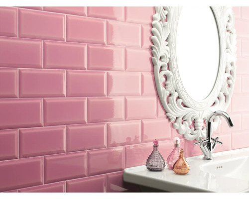 Salle de bains avec carreaux de métro rose brillant, lavabo, miroir avec cadre orné et robinet