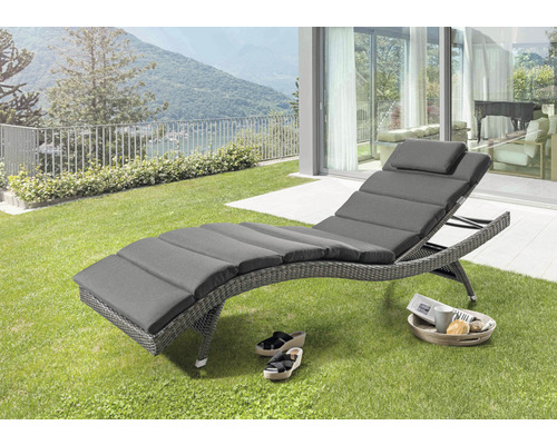 Scène de jardin avec une chaise longue tressée grise avec rembourrage