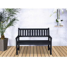 Banc de jardin en bois avec accoudoirs devant un mur blanc