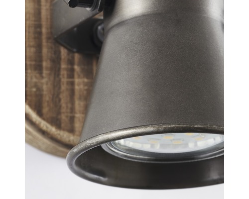 Detailansicht einer Wandleuchte mit Metallelementen und Holzakzent