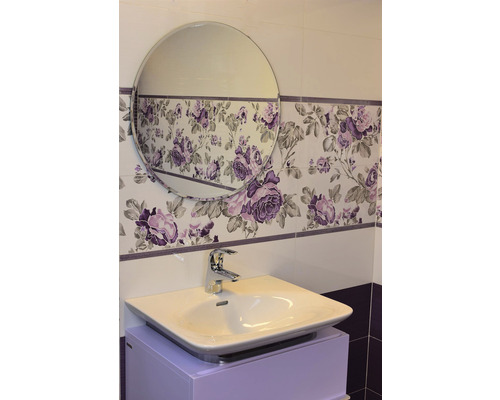 Badezimmer mit Waschbecken, Armatur und Spiegel vor Wandfliesen mit Blumenmuster
